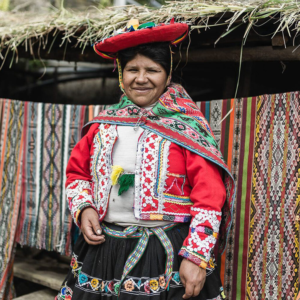 Mujer quechua frente a telares tradicionales en Awana Kancha