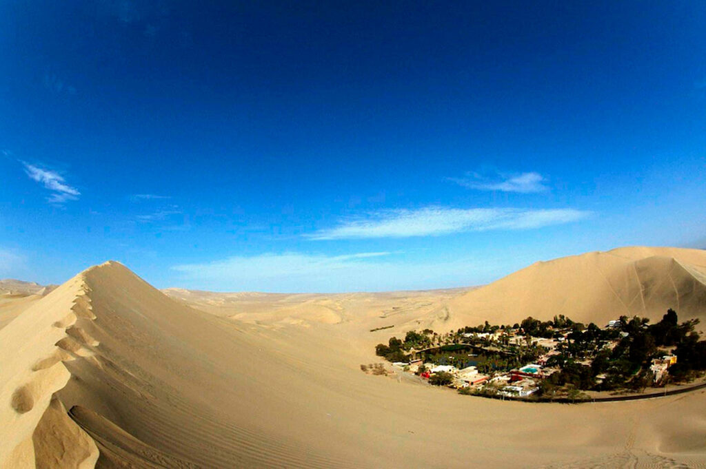 Vista panorámica de las dunas de Huacachina junto al oasis en medio del desierto de Ica