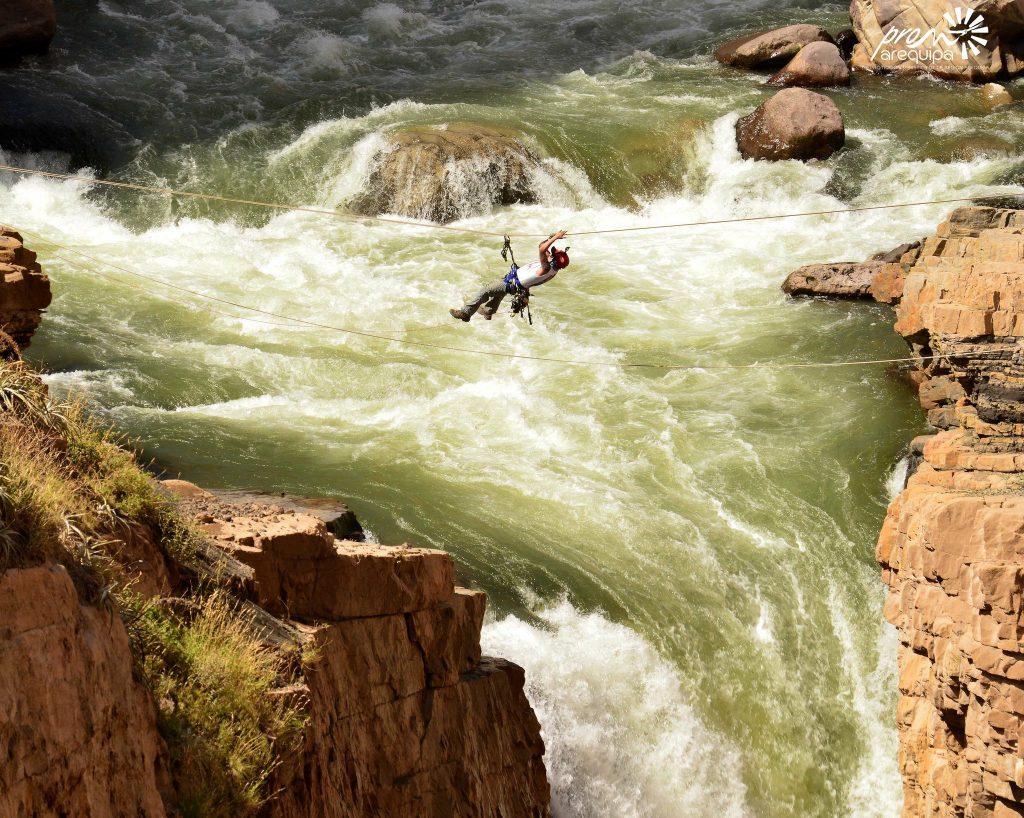hombre cruzando el rio en una cuerda