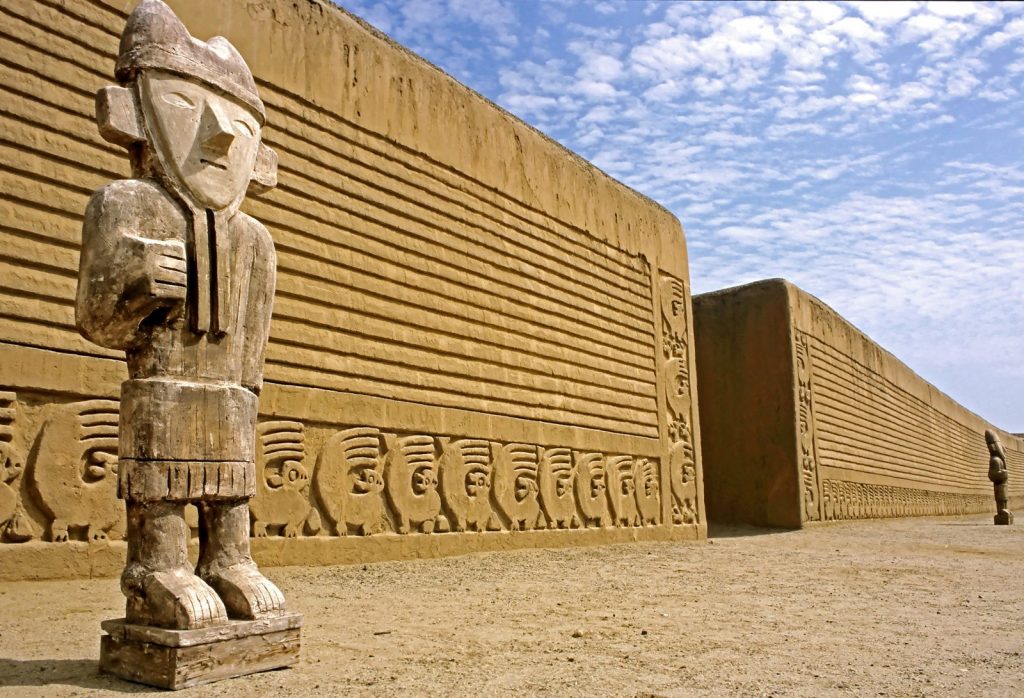 Escultrua de barro en frente de un muro de adobe
