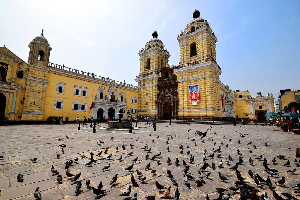 iglesia de color amarillo con palomas