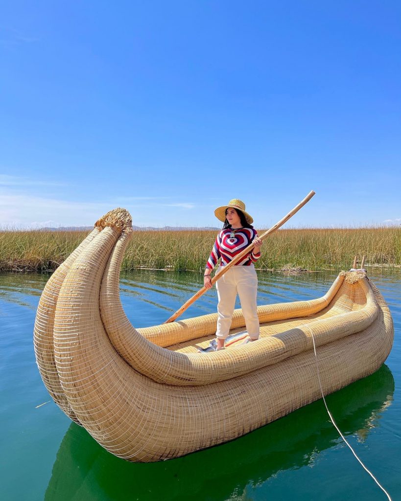 mujer sobre un barco de totora