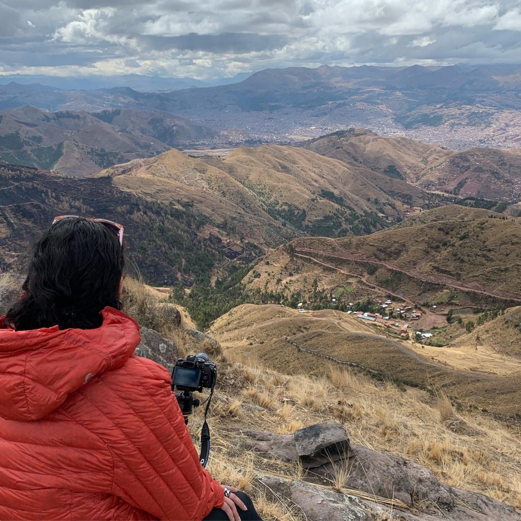 mujer tomando fotos de una montaña