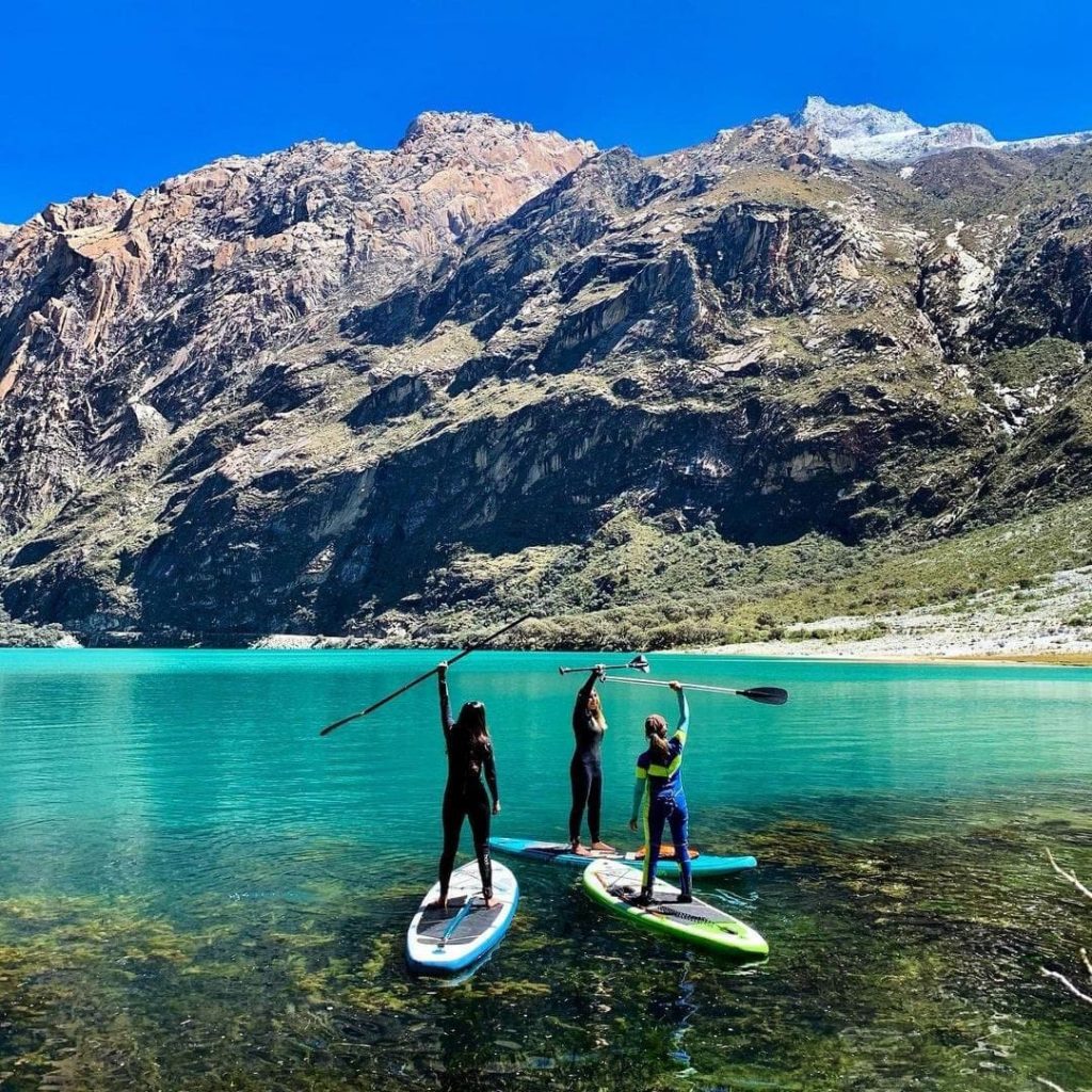 mujeres navegando en una laguna color turquesa