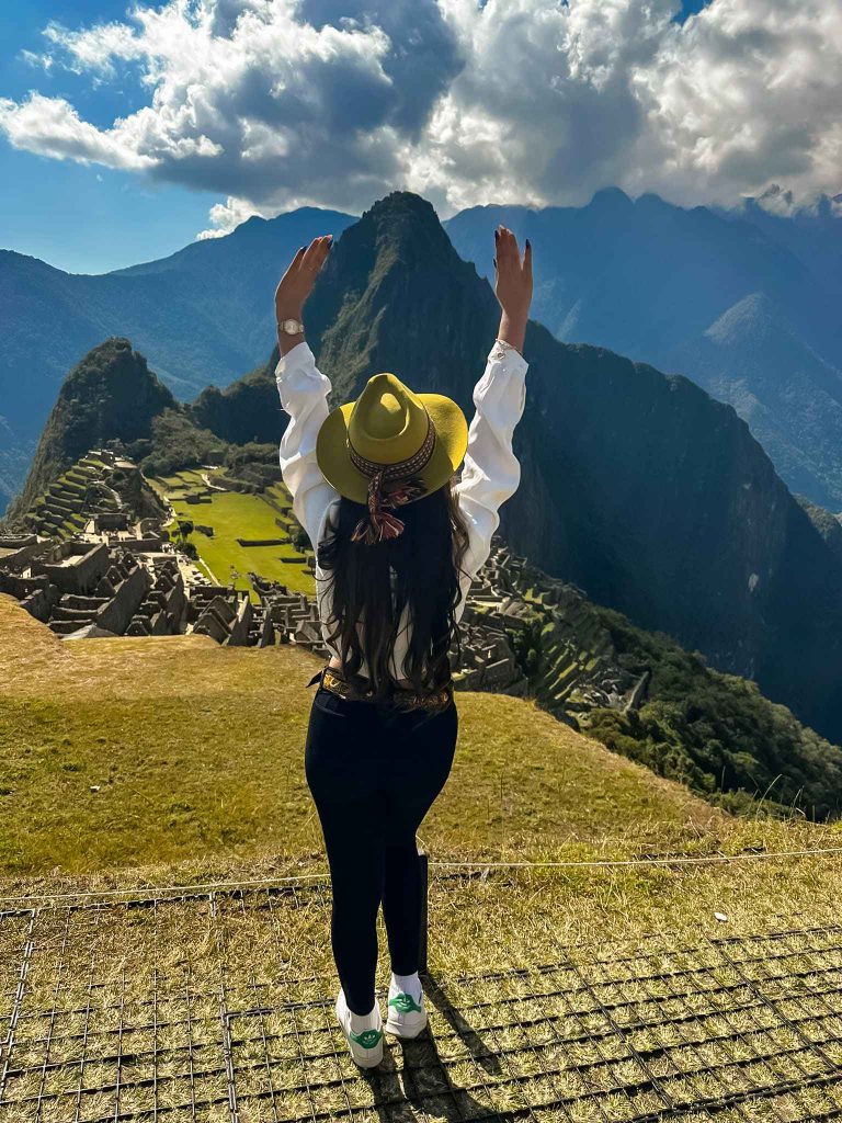 mujer levantando las mandos en frente de una montaña