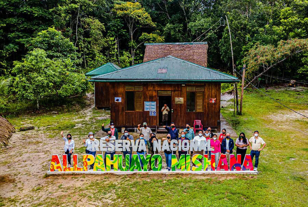 Entrada principal de la Reserva Nacional Allpahuayo Mishana con visitantes posando frente al letrero colorido