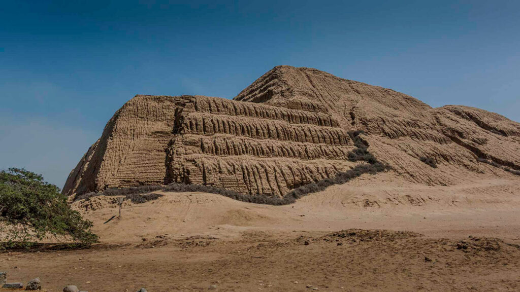 Vista frontal de la Huaca del Sol, templo principal de la cultura Moche en la costa norte del Perú, construido en adobe con diseño escalonado