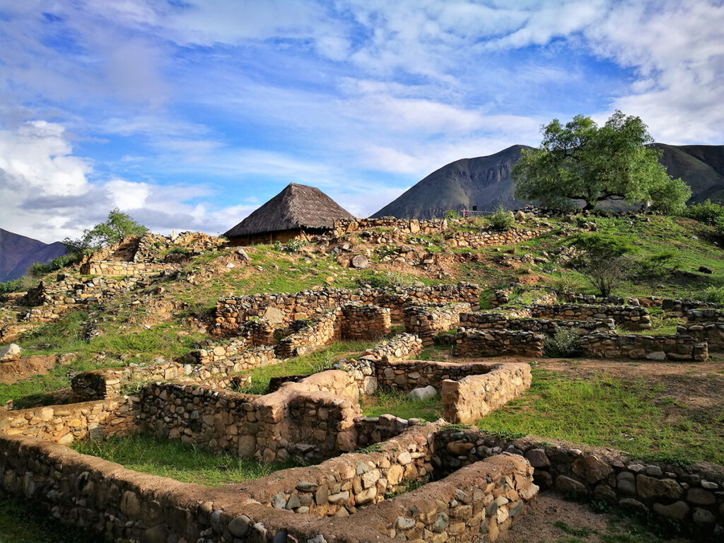 Restos arqueológicos del centro ceremonial de Kotosh, con estructuras de piedra y entorno andino que reflejan las tradiciones preincaicas de Huánuco