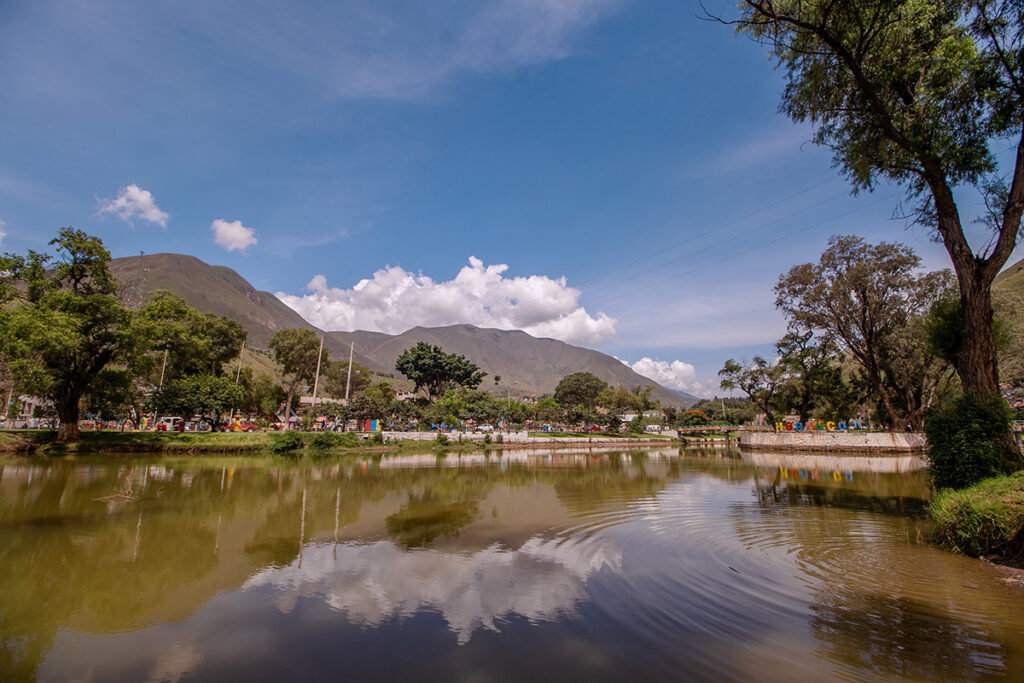 Paisaje urbano de Huánuco con laguna, áreas verdes y montañas andinas al fondo, reflejando la transición entre la sierra y la selva