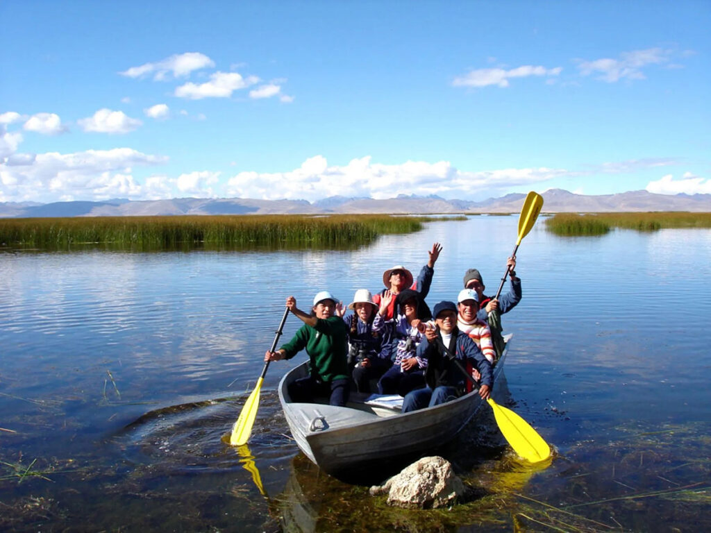 Turistas en paseo en bote por los totorales del Lago Junín, dentro de la Reserva Nacional de Junín en los Andes centrales del Perú