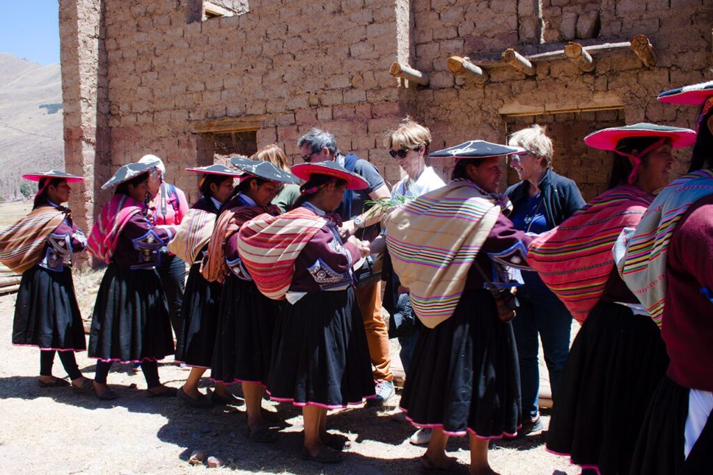 Mujeres de la comunidad andina de Raqchi comparten sus tradiciones con visitantes durante una jornada de turismo comunitario en el Valle Sagrado del Cusco