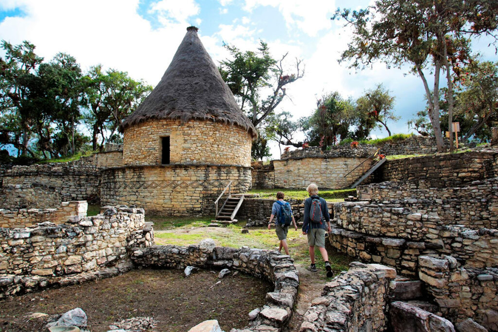 Recintos circulares restaurados en Kuélap, con techos de paja y visitantes recorriendo la fortaleza ancestral en Amazonas, Perú