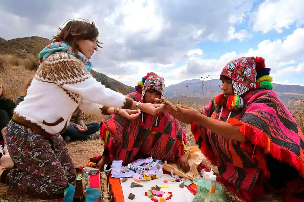 ritual andino de pago a la tierra con ofrendas y participantes vestidos con trajes tradicionales en los Andes del Perú