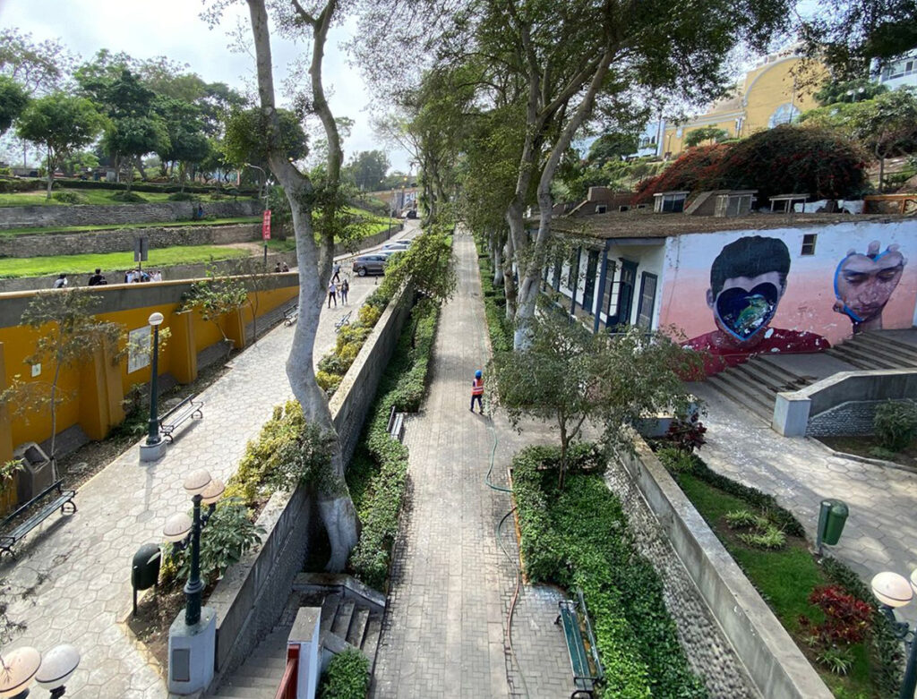 Vista actual de la bajada de baños en barranco, con senderos arbolados, murales urbanos y arquitectura trasdicional limeña