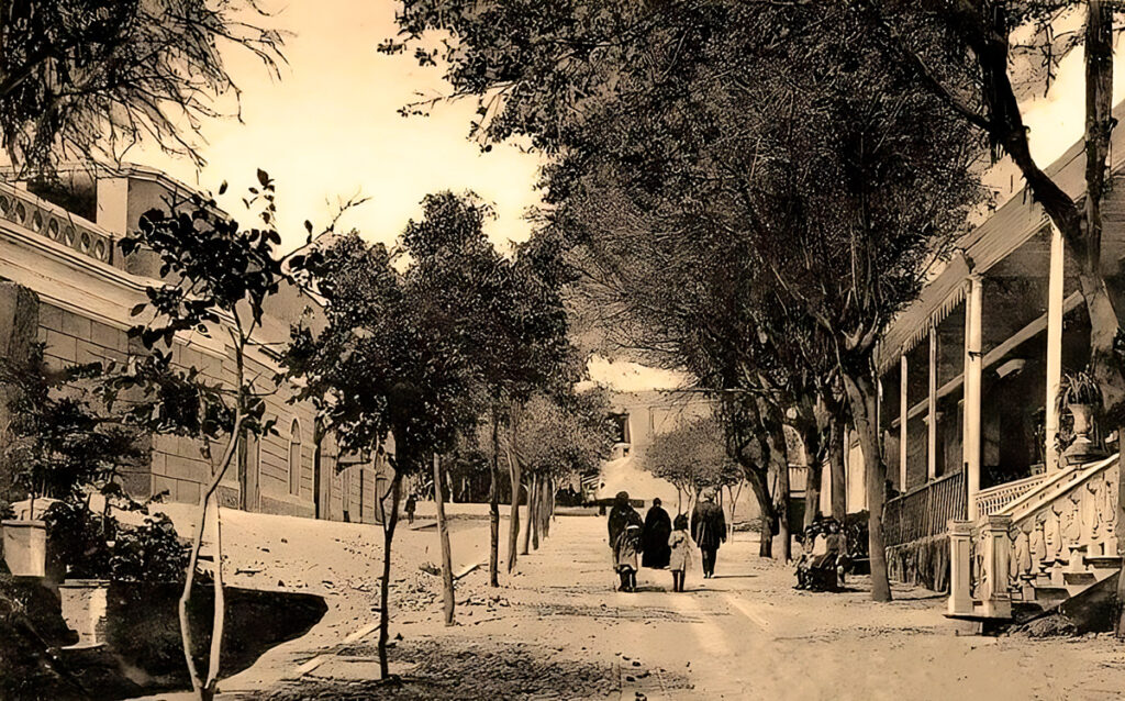 Fotografía antigua de la bajada de baños en el distrito de Barranco, tomada en 1907, muestra el paseo tradicional con árboles y casonas republicanas