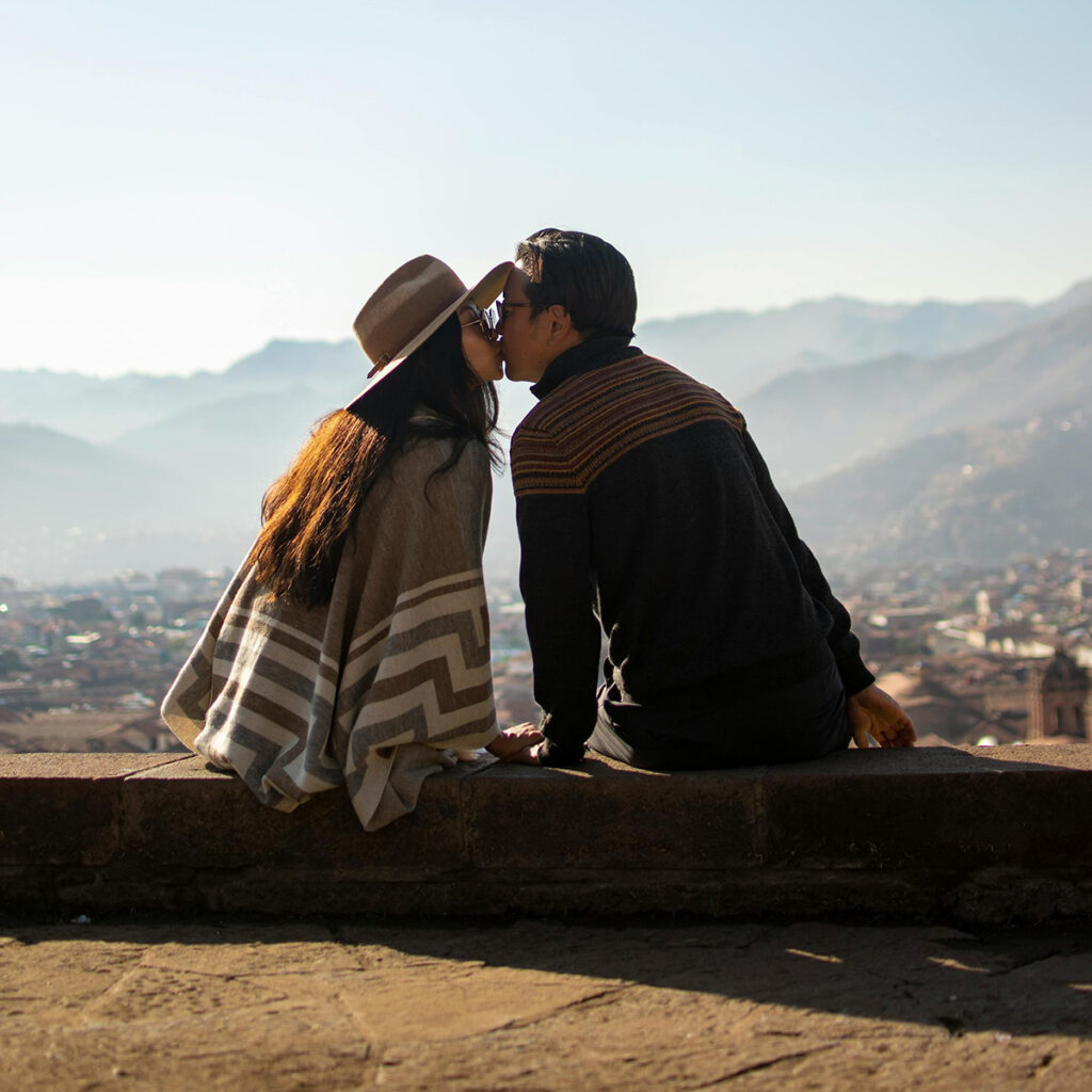 Pareja besándose en el mirador de San Cristóbal con las luces del atardecer