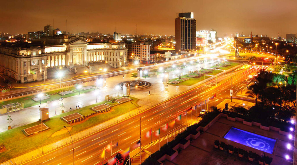 Vista nocturna del Paseo de los Héroes Navales y la Plaza Grau en Lima, con iluminación urbana frente al palacio de justicia