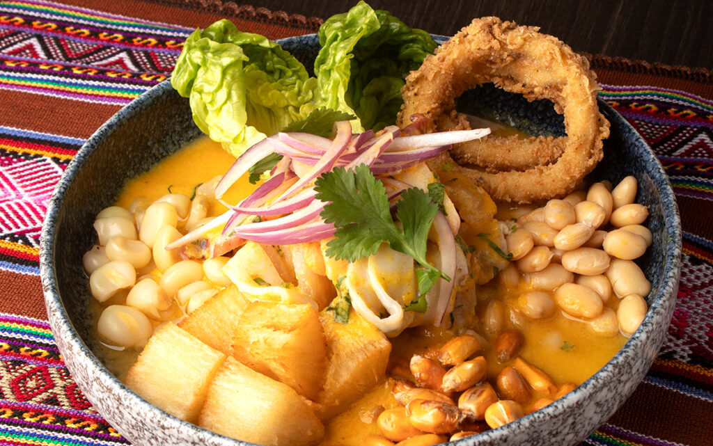 Plato de ceviche norteño servido con chifle, yuca y mote, resaltando los ingredientes frescos y tradicionales de la costa norte del Perú