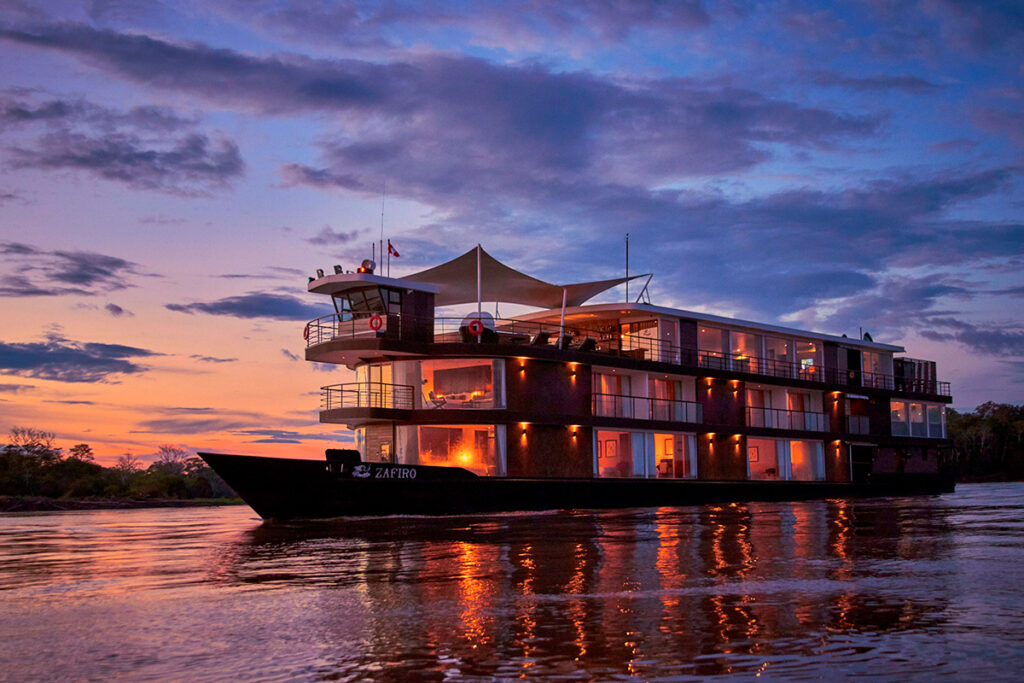 Crucero turístico navegando al atardecer por el río Amazonas en Perú