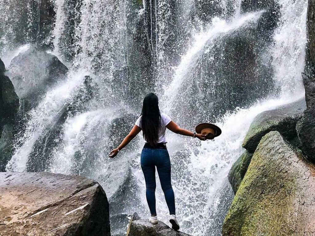 Mujer disfrutando de las aguas de la catarata de Pillones, en la región de Arequipa, Perú