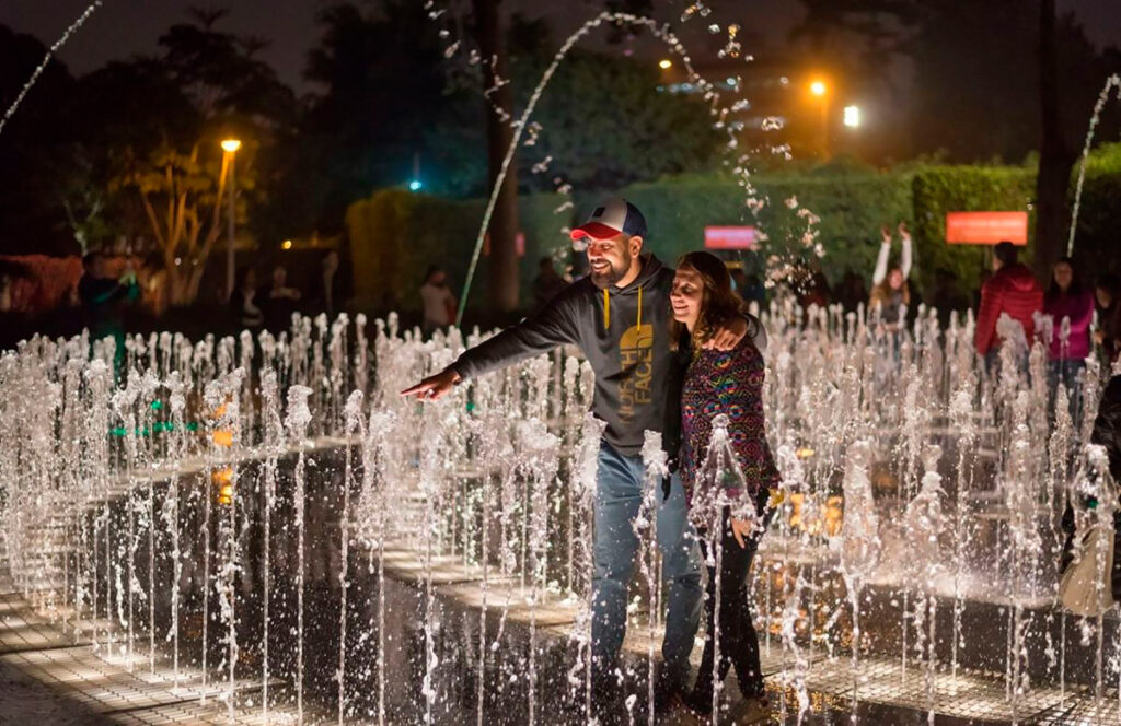 Pareja disfrutando de un momento recreativo en una de las fuentes de l circuito del parque de las aguas en Lima
