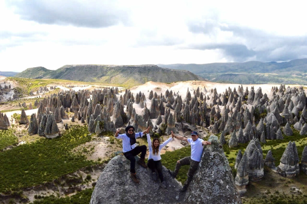 Un grupo de tres turistas disfrutan de las hermosas formaciones rocosas del bosque de piedras de pampachiri