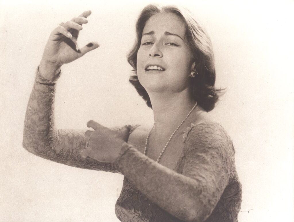 Retrato de la cantante y compositora Chabuca Granda, con una mano elevada, interpretando una de sus canciones 