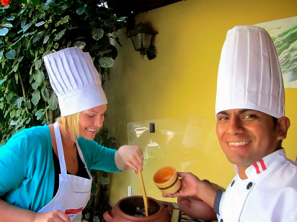 Turista participando de una clase de cocina peruana, preparando platos típicos con chefs locales