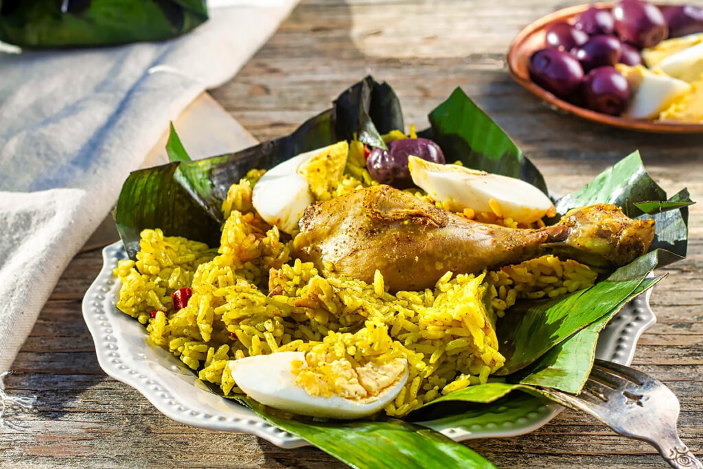 Juane de gallina envuelto en hojas de bijao, servido con arroz amarillo, huevo duro y aceitunas, plato tradicional de la Amazonía peruana