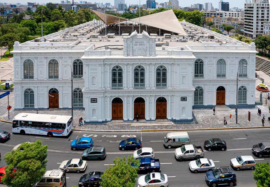 Fachada del museo de arte de lima, con un estilo neorrenacentista, visto desde las calles limeñas, rodeado de árboles y edificios