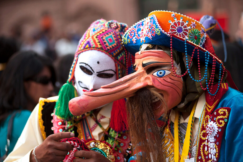 Personas con máscaras festivas de paucartambo y trajes típicos para las festividades