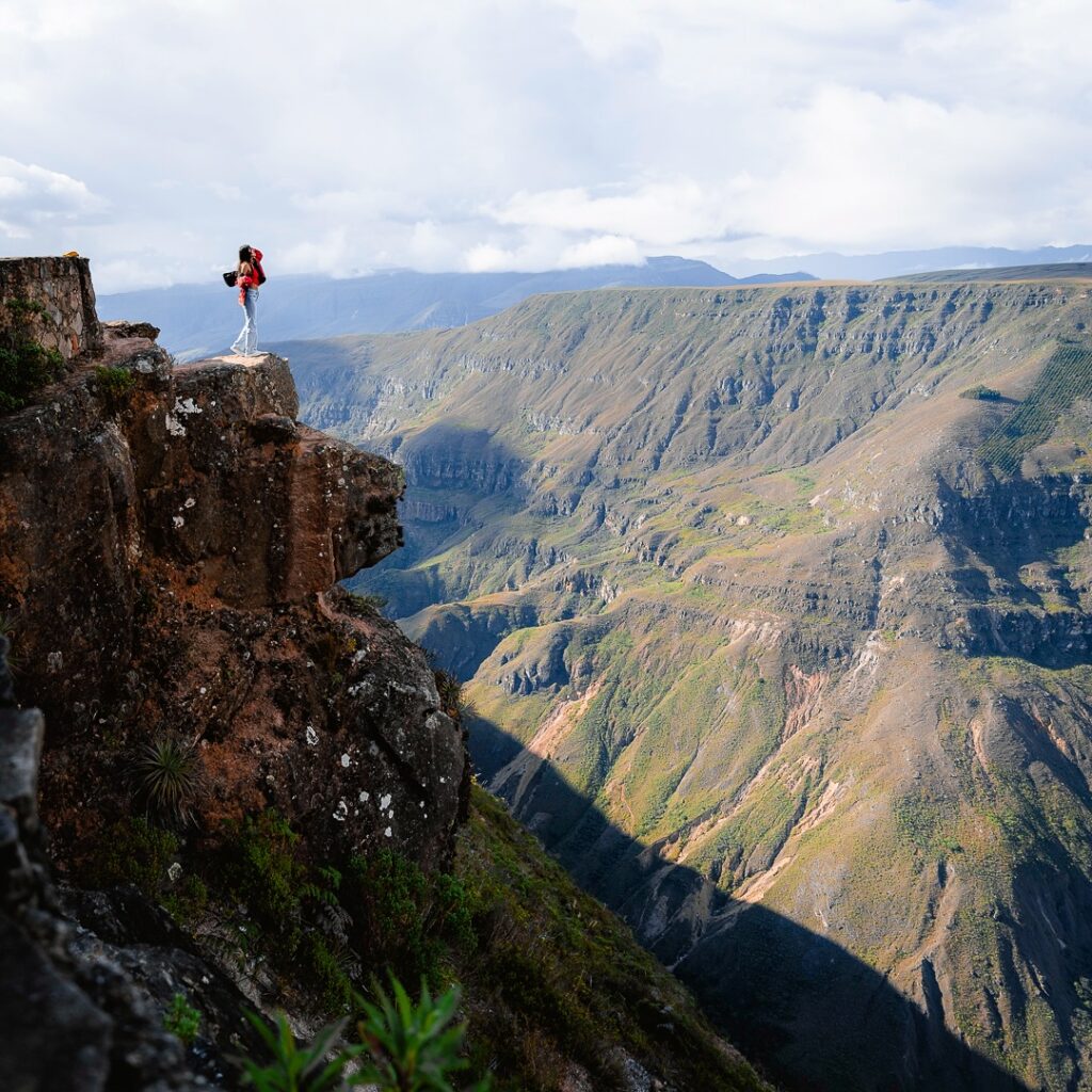 Persona sobre una formación rocosa con vista panorámica del Cañón del Sonche, en la región Amazonas