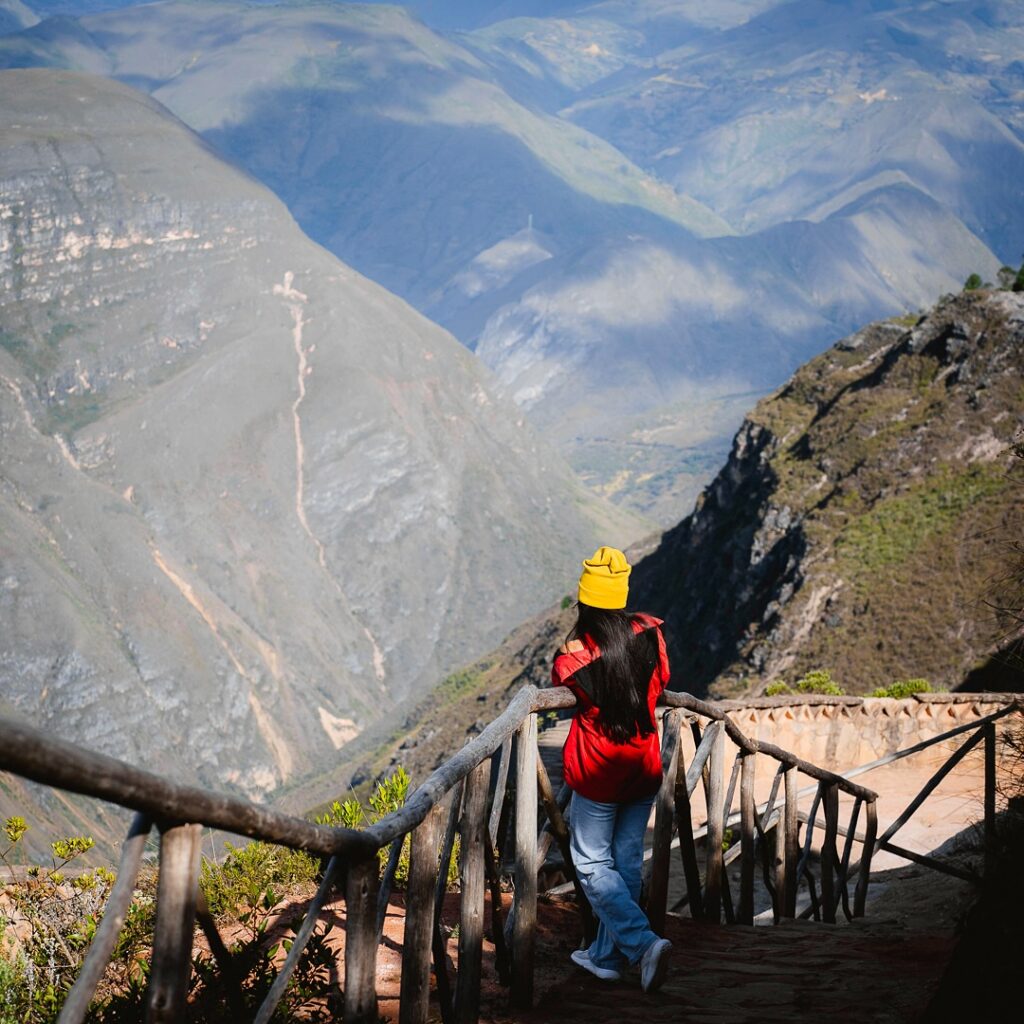 Persona con gorro amarillo frente al Cañón del Sonche, vista desde el mirador de madera en Huancas
