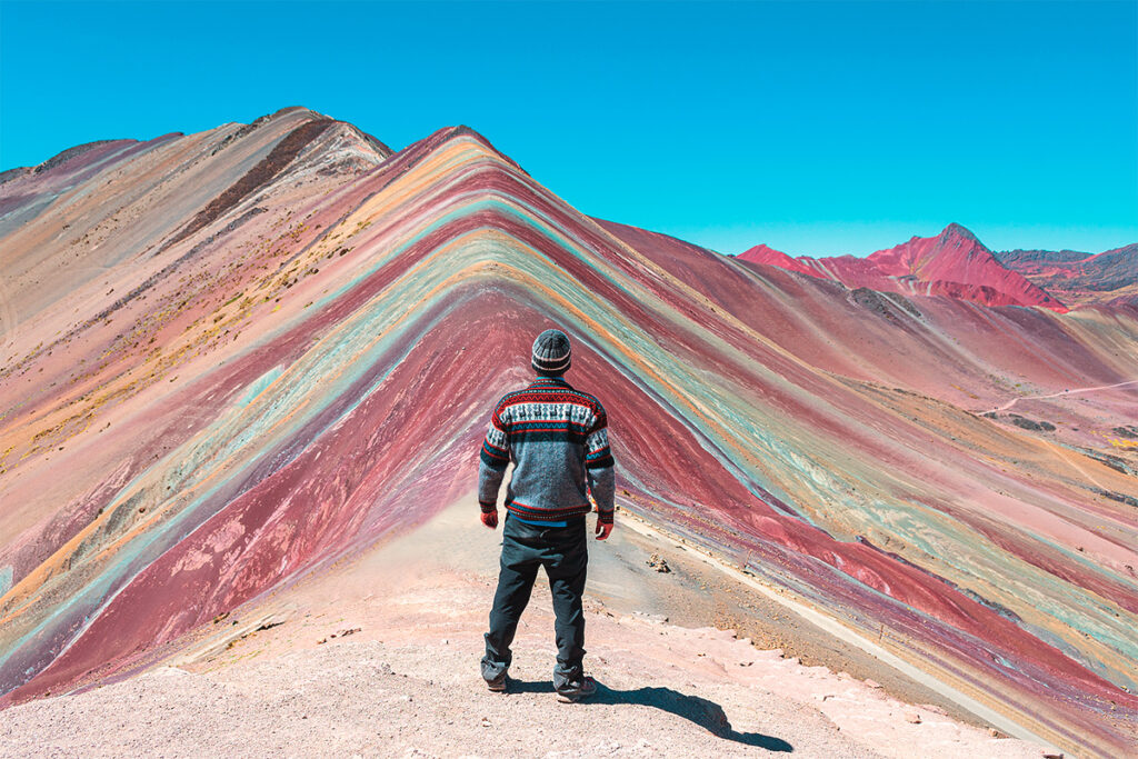 Turista contempla de pie la famosa montaña de 7 colores, conocida como Vinicunca, en la región de Cusco