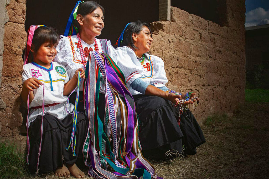 Tres generaciones de quechuas lamistas, abuela, madre y nieta, vestidas con el atuendo típico de la comunidad 