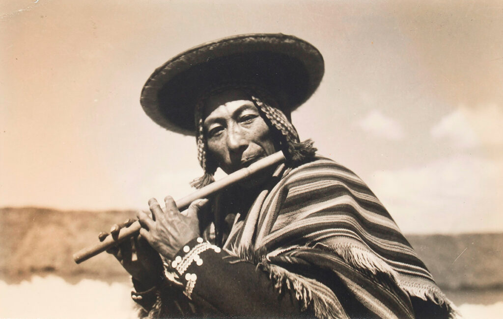 músico de quena, vestido con un poncho y traje típico de la zona, fotografiado por Martín Chambi
