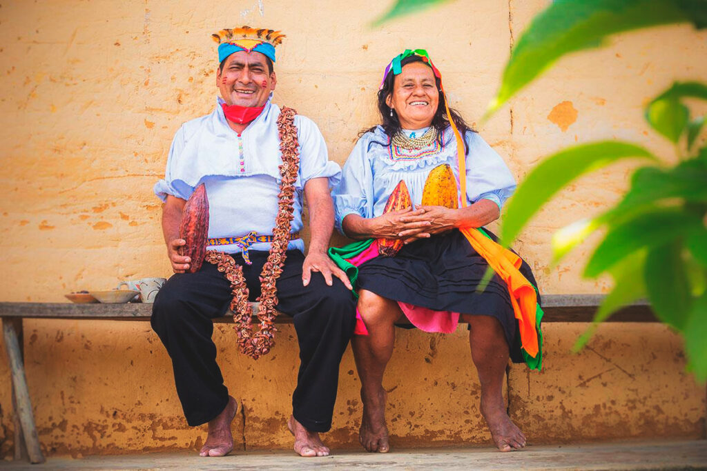 Pobladores indígenas de la comunidad quechua lamista, con frutos de cacao en los brazos, vestidos con atuendos típicos de la zona