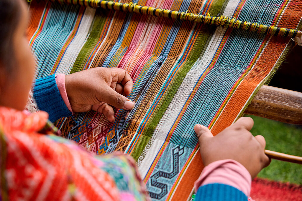 Tejedora de chinchero haciendo una manta con lana de alpaca