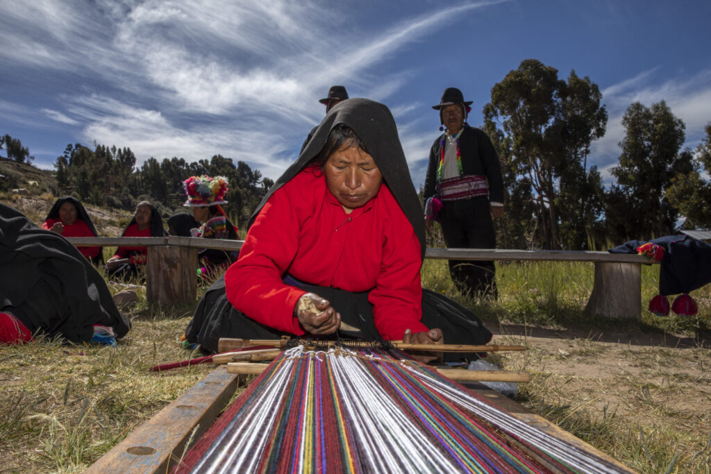 Mujer de las alturas de Taquile, fabricando una prenda de vestir con un telar