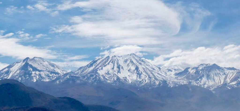 Cordillera volcánica del sur del perú con cumbres nevadas, vistas del volcán Chachani bajo un ciclo parcialmente despejado