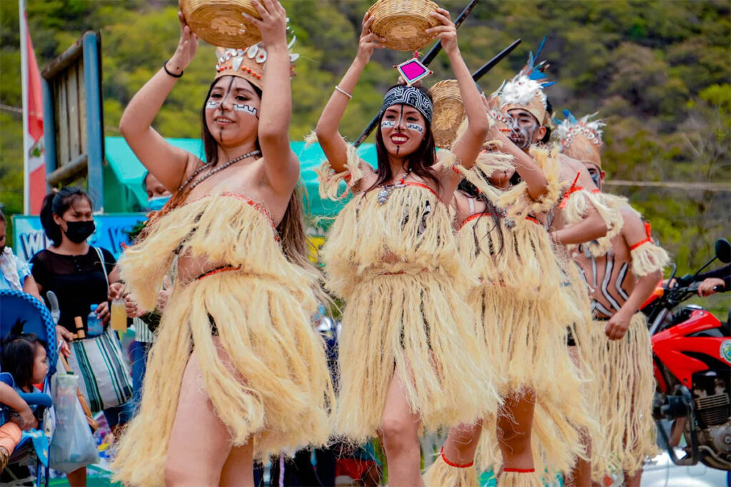 Mujeres vestidas con atuendos típicos de la selva, participando en una danza durante las festividades de San Juan 