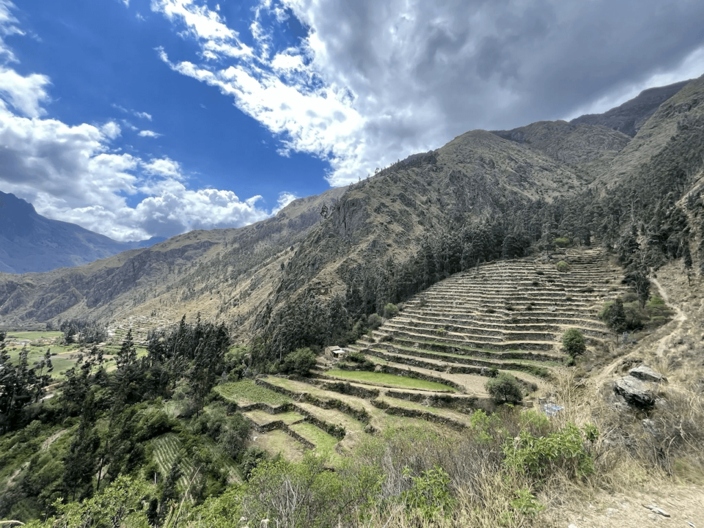 Terrazas incas en medio de las montañas y el paisaje andino, bajo un cielo parcialmente nublado, de camino a Pumamarca