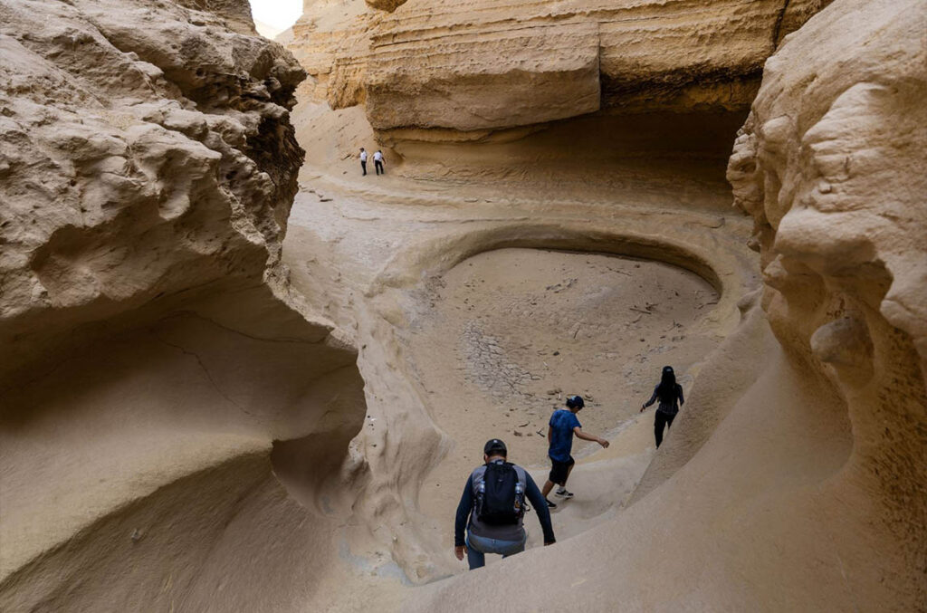 Grupo de visitantes recorriendo una de las formaciones internas del Cañón de los Perdidos, en el desierto de Ica