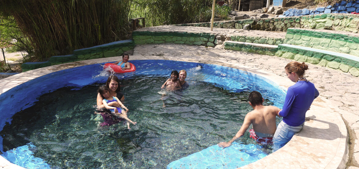 Turistas disfrutando de las pozas termales de Cconoc en un entorno natural rodeado de vegetación, en la región Apurímac, Perú