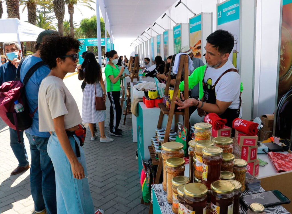 Visitantes recorren una feria artesanal en Perú, con exhibición de productos locales y tradiciones culturales