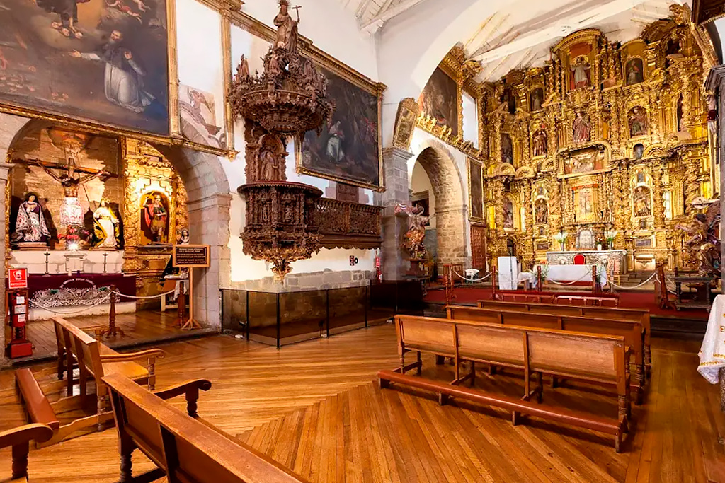 Vista interior de la Iglesia de San Blas en Cusco, mostrando el altar mayor, retablos coloniales y bancas de madera en un ambiente sereno