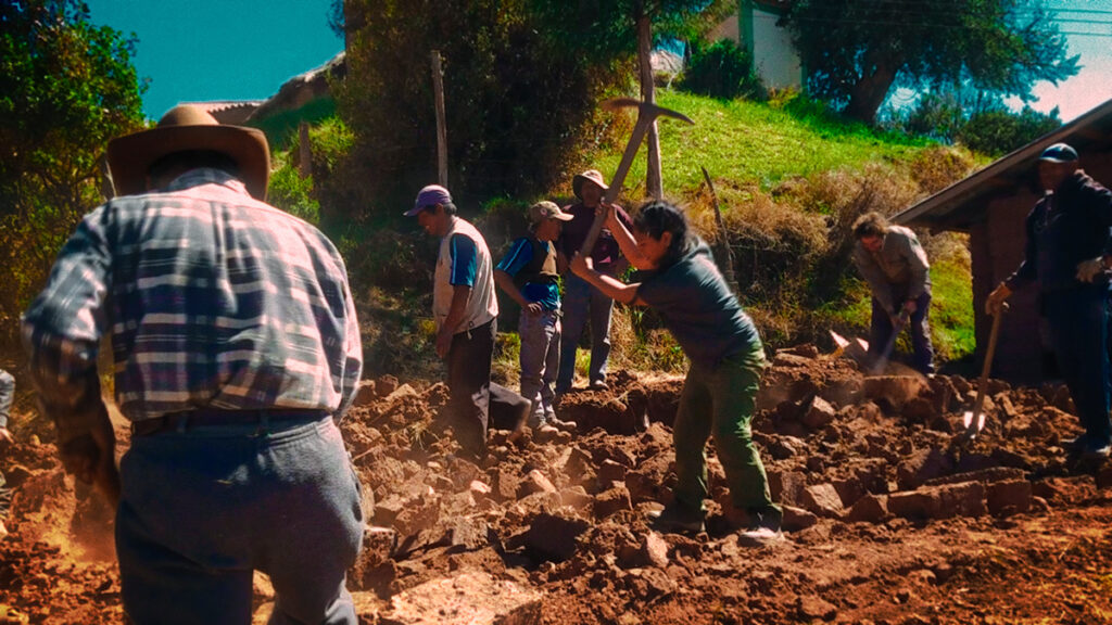 Comuneros andinos realizando una faena comunal en el campo como parte de la tradición del ayni o minka
