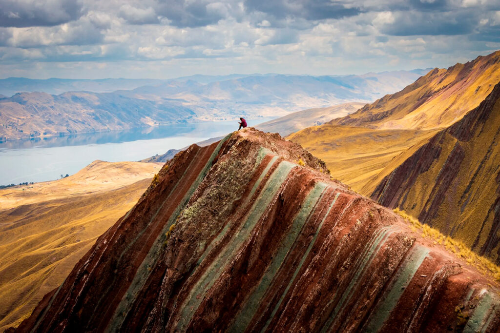 Montaña de colores de Pallay Punchu con franjas diagonales y vista al lago desde el distrito de Layo