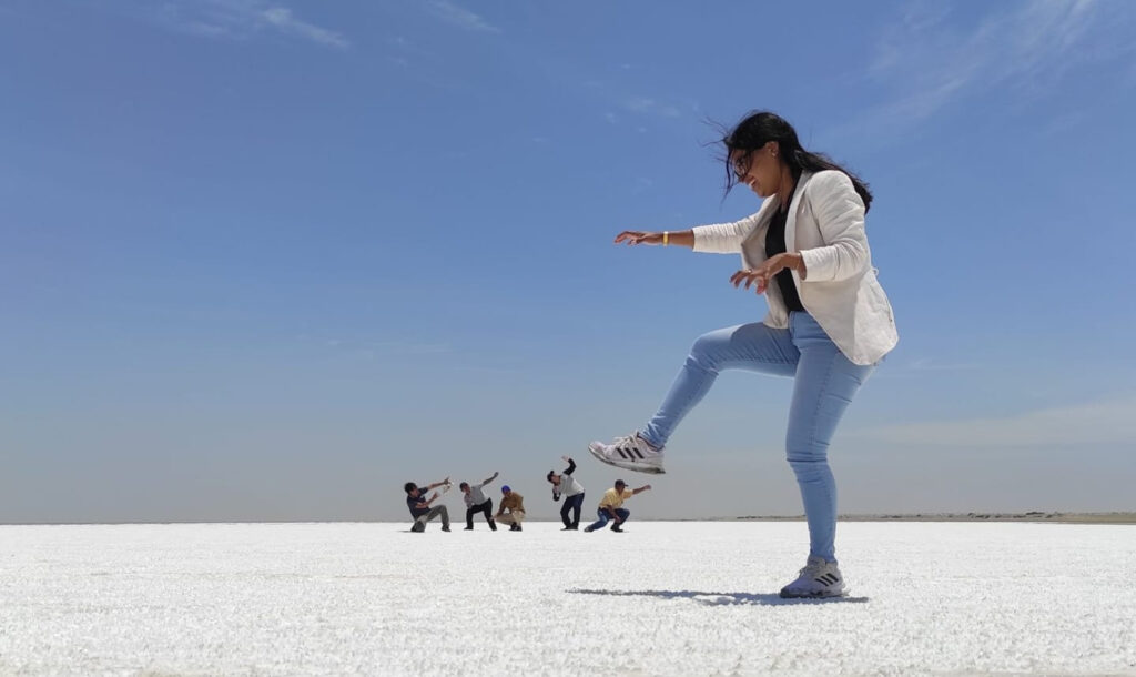 Turistas posan en el salar de Sechura, creando efectos visuales sobre el paisaje blanco y cielo despejado