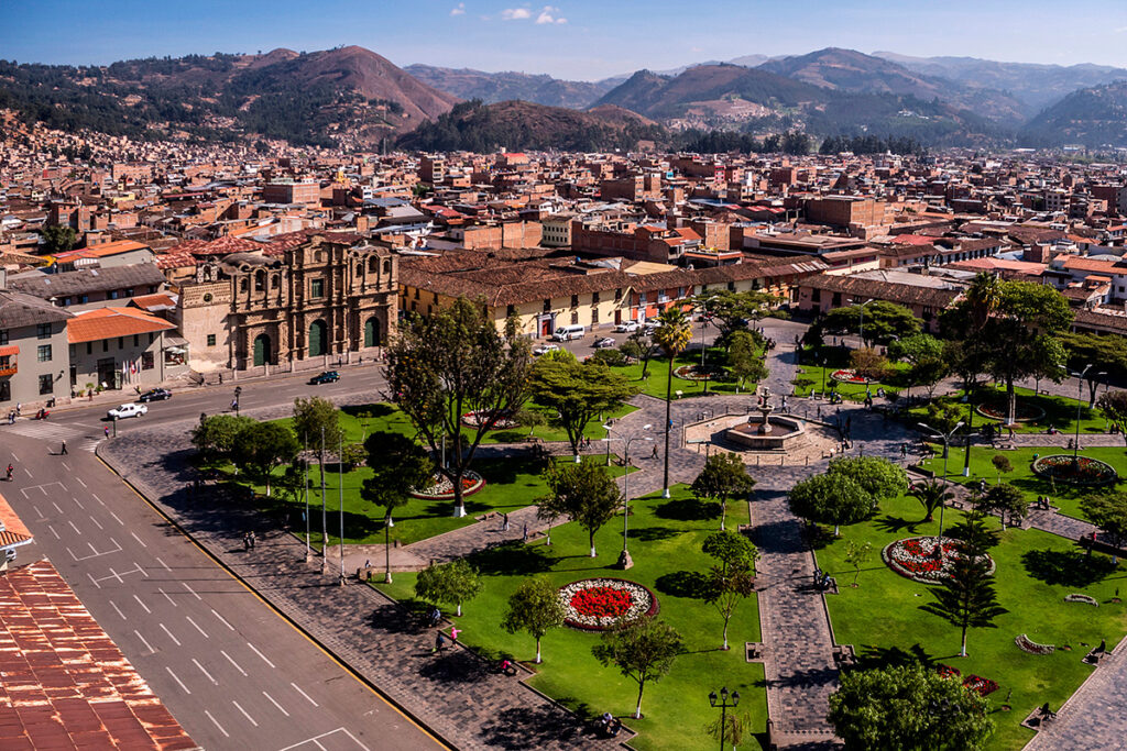 Vista panorámica de la Plaza Mayor de Cajamarca con jardines, la Catedral y el fondo montañoso iluminado por luz matinal
